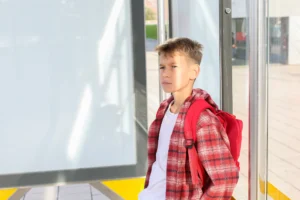 teenager-waiting-the-bus-at-the-stop-in-the-city-2026-03-25-07-24-33-utc | Pinwheel Clinic | Pinwheel Clinic Child looking sad or frustrated not wanting to be at school